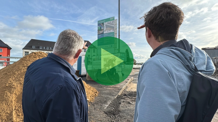 Zwei Männer blicken auf ein Baustellenschild