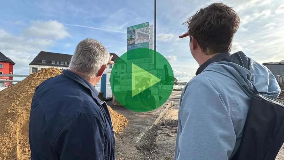 Zwei Männer blicken auf ein Baustellenschild